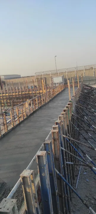 A cast concrete surface within side forms beside reinforcement.