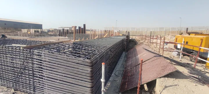 A dense reinforcement cage beside a temporary access platform.