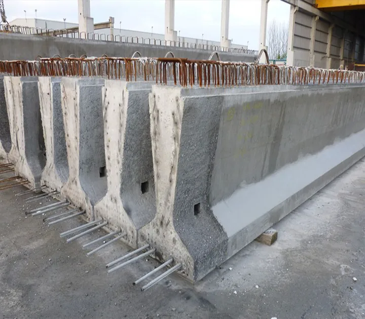 A row of precast concrete barriers with exposed reinforcing bars.